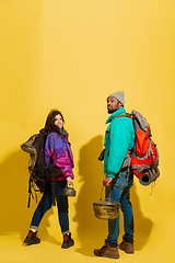 Image showing Portrait of a cheerful young tourist couple isolated on yellow background