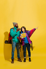 Image showing Portrait of a cheerful young tourist couple isolated on yellow background