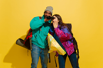 Image showing Portrait of a cheerful young tourist couple isolated on yellow background