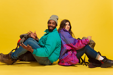 Image showing Portrait of a cheerful young tourist couple isolated on yellow background