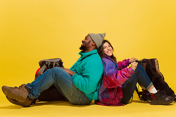 Image showing Portrait of a cheerful young tourist couple isolated on yellow background