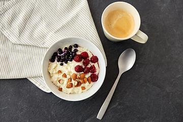 Image showing porridge breakfast with berries, almonds and spoon