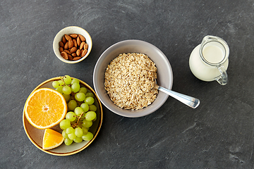 Image showing oatmeal with fruits, almond nuts and jug of milk