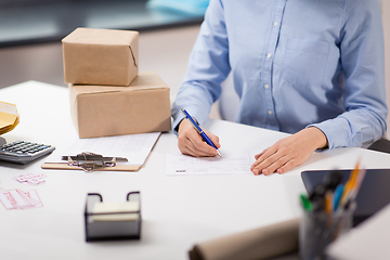 Image showing close up of woman filling postal form at office