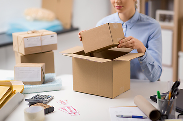 Image showing woman packing parcel box at post office