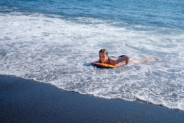 Image showing girl swimming on board in ocean