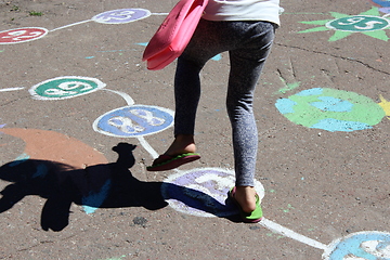 Image showing girl runs on the childish drawings on the asphalt