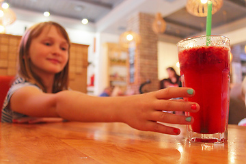 Image showing young girl drinks a lemonade