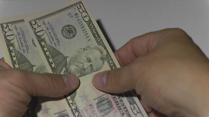 Image showing Man counting money of one thousand US dollars. UltraHD stock footage