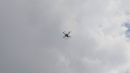 Image showing Flying helicopter dron on a background of white clouds