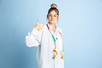 Image showing Young girl dreaming about future profession of seamstress