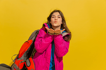 Image showing Portrait of a cheerful young caucasian tourist girl isolated on yellow background