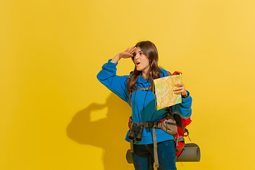 Image showing Full length portrait of a cheerful young caucasian tourist girl isolated on yellow background