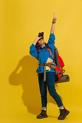 Image showing Full length portrait of a cheerful young caucasian tourist girl isolated on yellow background