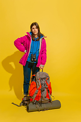 Image showing Full length portrait of a cheerful young caucasian tourist girl isolated on yellow background