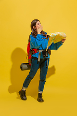 Image showing Full length portrait of a cheerful young caucasian tourist girl isolated on yellow background