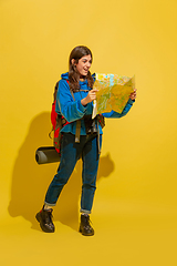 Image showing Full length portrait of a cheerful young caucasian tourist girl isolated on yellow background