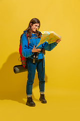 Image showing Full length portrait of a cheerful young caucasian tourist girl isolated on yellow background