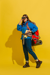 Image showing Full length portrait of a cheerful young caucasian tourist girl isolated on yellow background