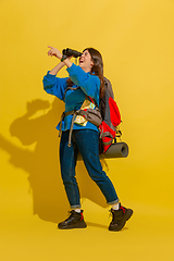 Image showing Full length portrait of a cheerful young caucasian tourist girl isolated on yellow background