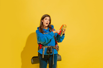 Image showing Full length portrait of a cheerful young caucasian tourist girl isolated on yellow background