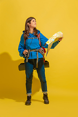 Image showing Full length portrait of a cheerful young caucasian tourist girl isolated on yellow background