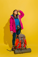 Image showing Full length portrait of a cheerful young caucasian tourist girl isolated on yellow background