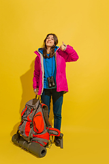 Image showing Full length portrait of a cheerful young caucasian tourist girl isolated on yellow background