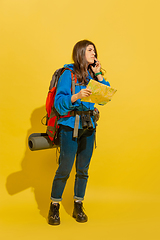 Image showing Full length portrait of a cheerful young caucasian tourist girl isolated on yellow background