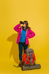 Image showing Full length portrait of a cheerful young caucasian tourist girl isolated on yellow background