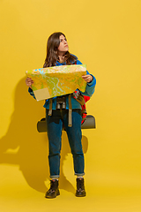 Image showing Full length portrait of a cheerful young caucasian tourist girl isolated on yellow background