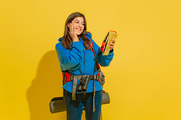 Image showing Full length portrait of a cheerful young caucasian tourist girl isolated on yellow background