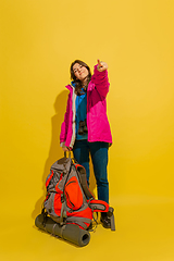 Image showing Full length portrait of a cheerful young caucasian tourist girl isolated on yellow background