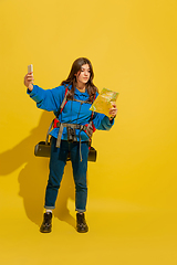 Image showing Full length portrait of a cheerful young caucasian tourist girl isolated on yellow background