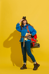 Image showing Full length portrait of a cheerful young caucasian tourist girl isolated on yellow background