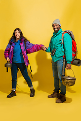 Image showing Portrait of a cheerful young tourist couple isolated on yellow background