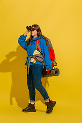 Image showing Full length portrait of a cheerful young caucasian tourist girl isolated on yellow background