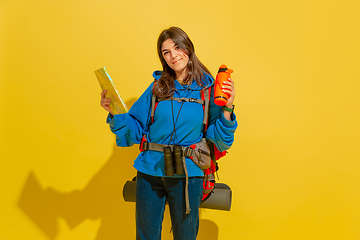 Image showing Full length portrait of a cheerful young caucasian tourist girl isolated on yellow background