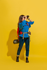 Image showing Full length portrait of a cheerful young caucasian tourist girl isolated on yellow background