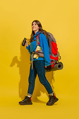 Image showing Full length portrait of a cheerful young caucasian tourist girl isolated on yellow background