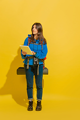 Image showing Full length portrait of a cheerful young caucasian tourist girl isolated on yellow background