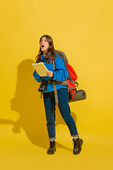 Image showing Full length portrait of a cheerful young caucasian tourist girl isolated on yellow background