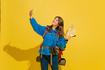 Image showing Full length portrait of a cheerful young caucasian tourist girl isolated on yellow background