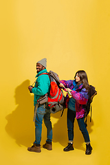 Image showing Portrait of a cheerful young tourist couple isolated on yellow background