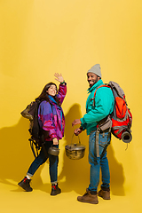 Image showing Portrait of a cheerful young tourist couple isolated on yellow background