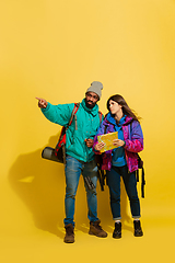 Image showing Portrait of a cheerful young tourist couple isolated on yellow background