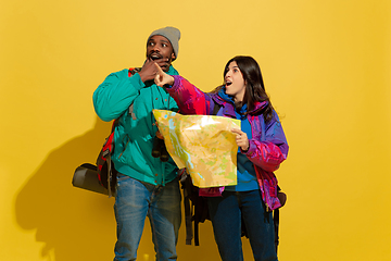 Image showing Portrait of a cheerful young tourist couple isolated on yellow background