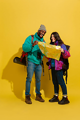 Image showing Portrait of a cheerful young tourist couple isolated on yellow background