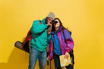 Image showing Portrait of a cheerful young tourist couple isolated on yellow background