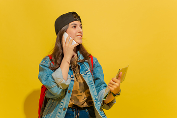 Image showing Portrait of a cheerful young caucasian tourist girl isolated on yellow background